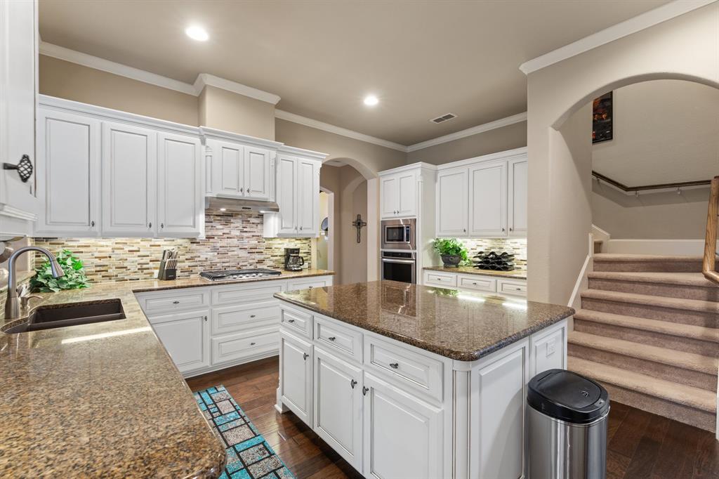 4711 Taylor Lane Grapevine, TX 76051 - Photo 9 of 31 a kitchen with kitchen island granite countertop a sink stove and cabinets
