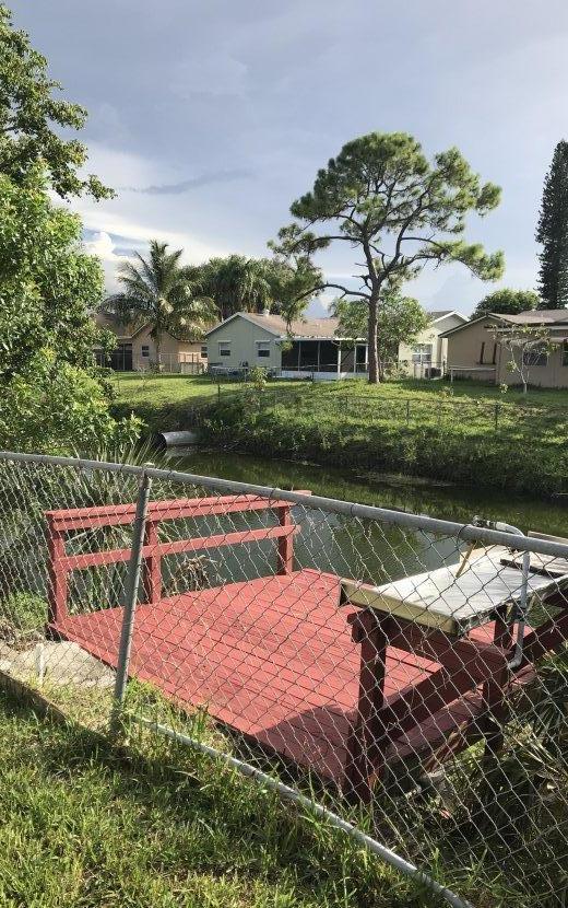 22705 Southwest 65th Terrace Boca Raton, FL 33428 - Photo 14 of 15 a view of a lake with a bench next to a lake