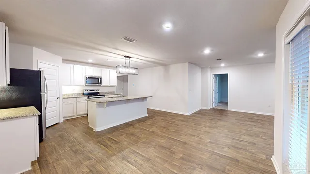 a large kitchen with kitchen island a sink stainless steel appliances and cabinets