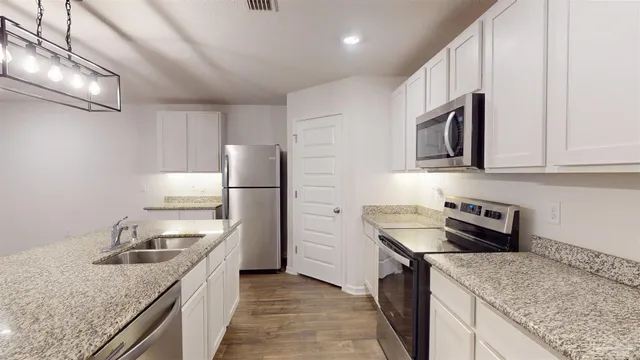 a kitchen with stainless steel appliances granite countertop a sink stove and refrigerator
