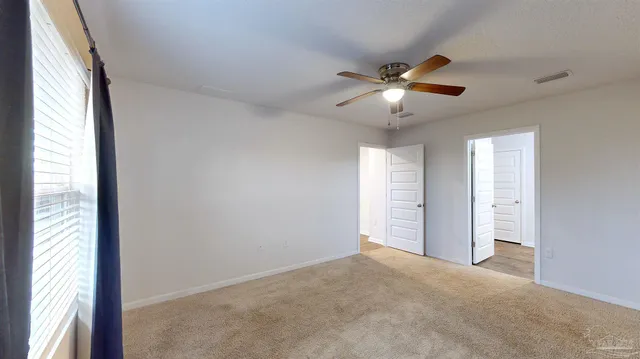 a view of a livingroom with a ceiling fan and window