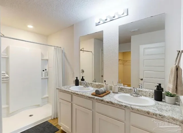 a bathroom with double sink and a mirror
