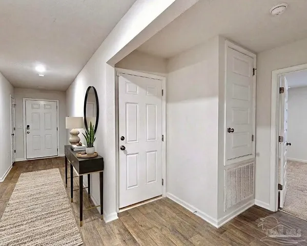 a view of a livingroom with wooden floor and entryway