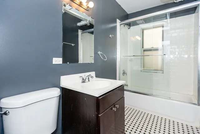 a bathroom with a sink a toilet a shower and a mirror