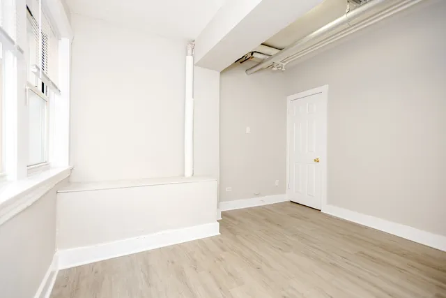 a view of a small space with wooden floor and a window