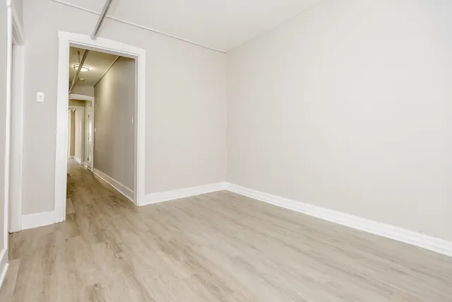 an empty room with wooden floor and closet