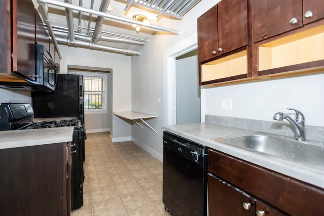 a kitchen with a sink a stove and cabinets