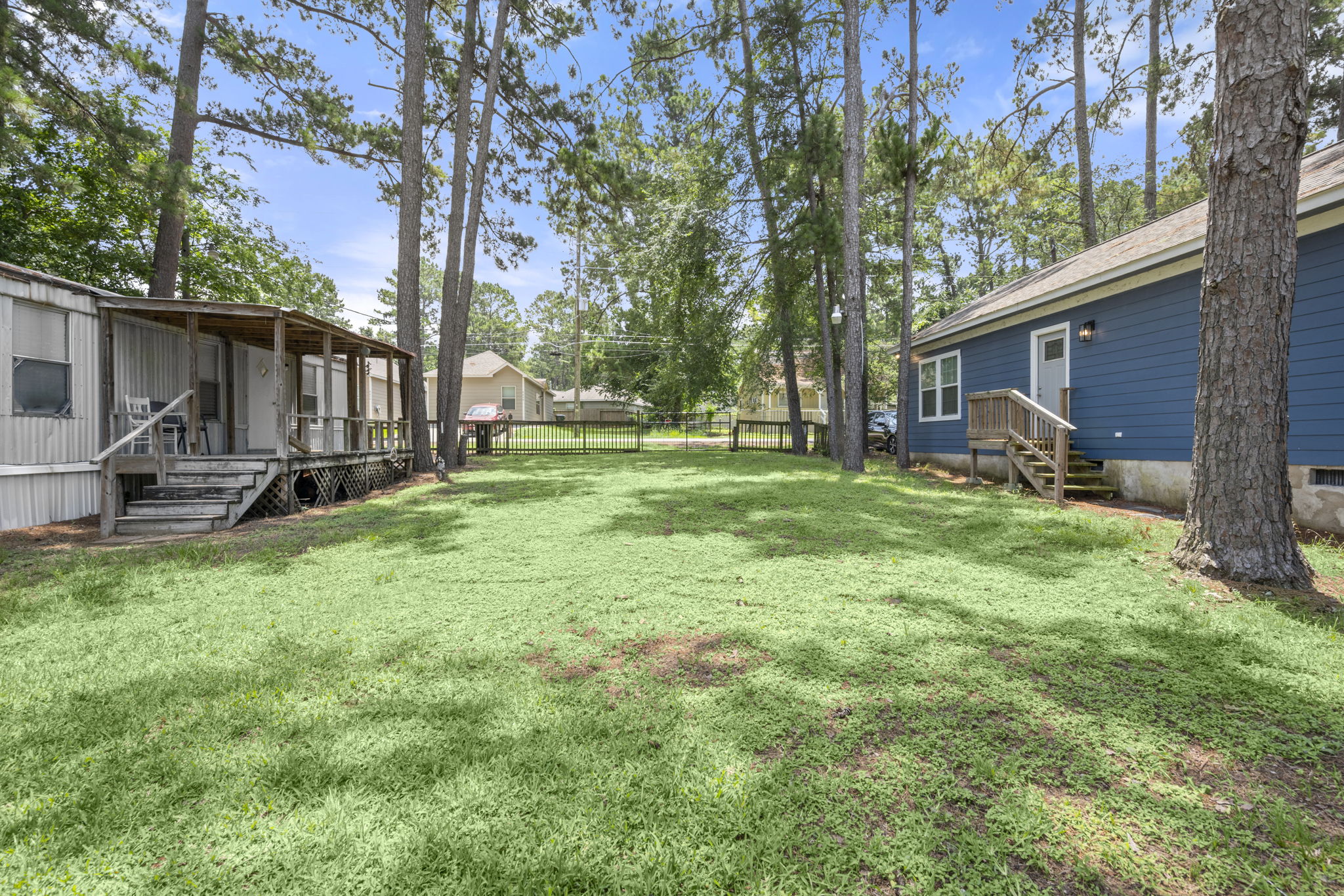 9649 Warm Spring Willis, TX 77318 - Photo 4 of 30 A verdant backyard with mature trees provides ample space for outdoor enjoyment.