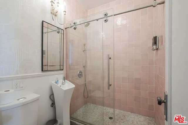 a bathroom with a shower a toilet and sink