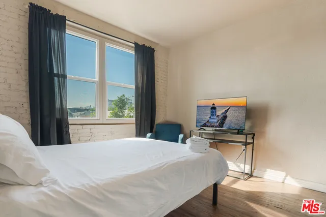 a bedroom with a bed and a flat screen tv