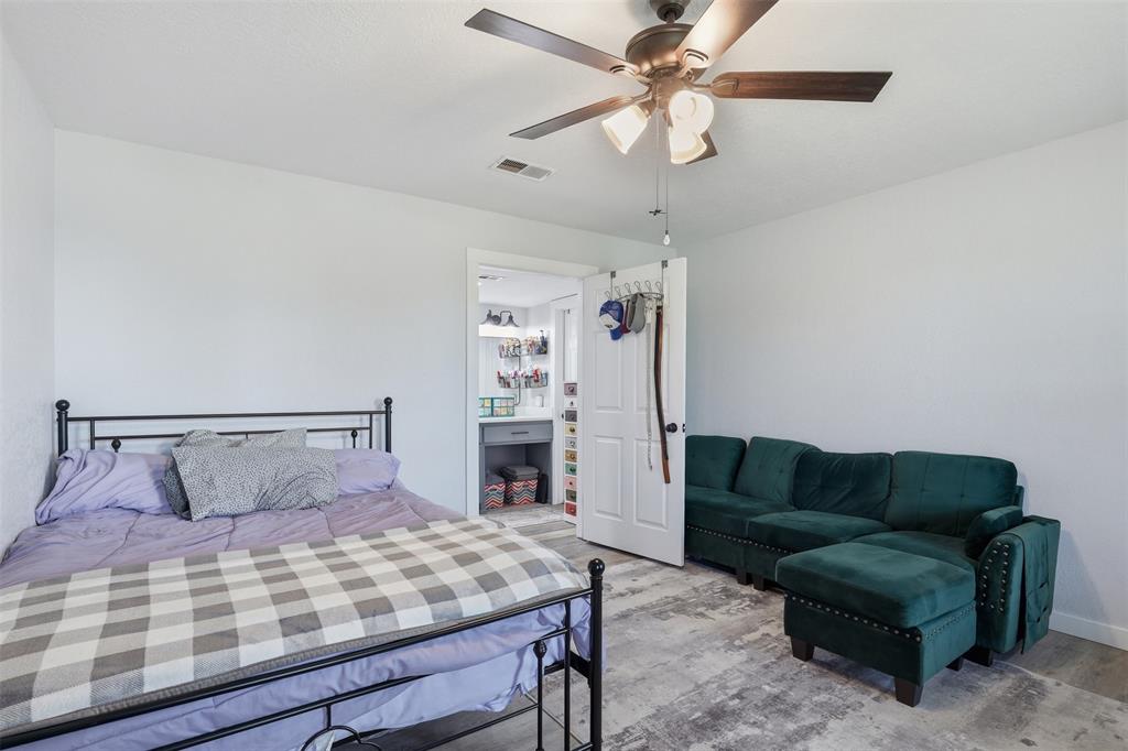 1865 Old Denton Highway Decatur, TX 76234 - Photo 21 of 35 a bedroom with a bed a couch and a chandelier