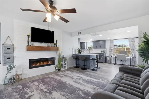 a living room with furniture a flat screen tv and a fireplace