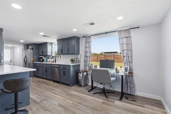 a kitchen with sink cabinets and wooden floor