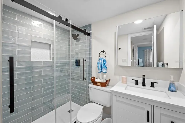 a bathroom with a toilet sink vanity and mirror