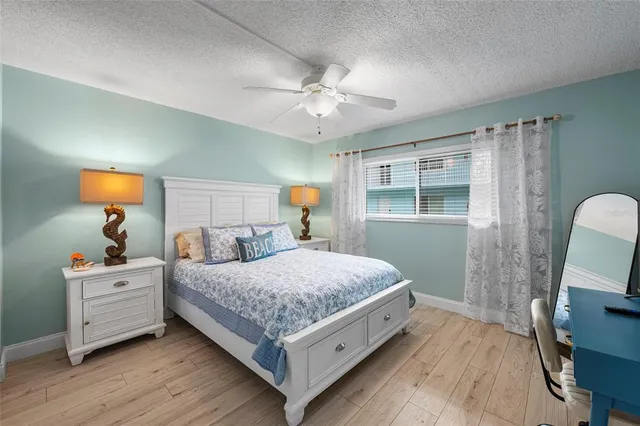 a bedroom with a bed and a flat tv screen on dresser