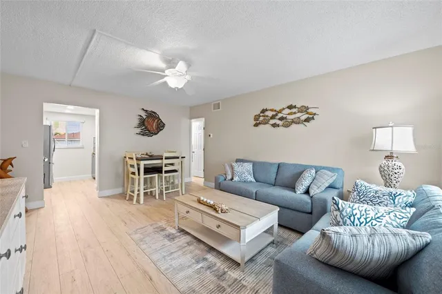 a living room with furniture a chandelier and a wooden floor