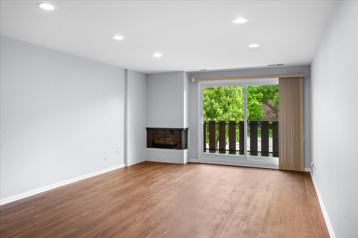 1795 Lake Cook Road, Unit 107 Highland Park, IL 60035 - Photo 7 of 26 a view of an empty room with wooden floor and a window