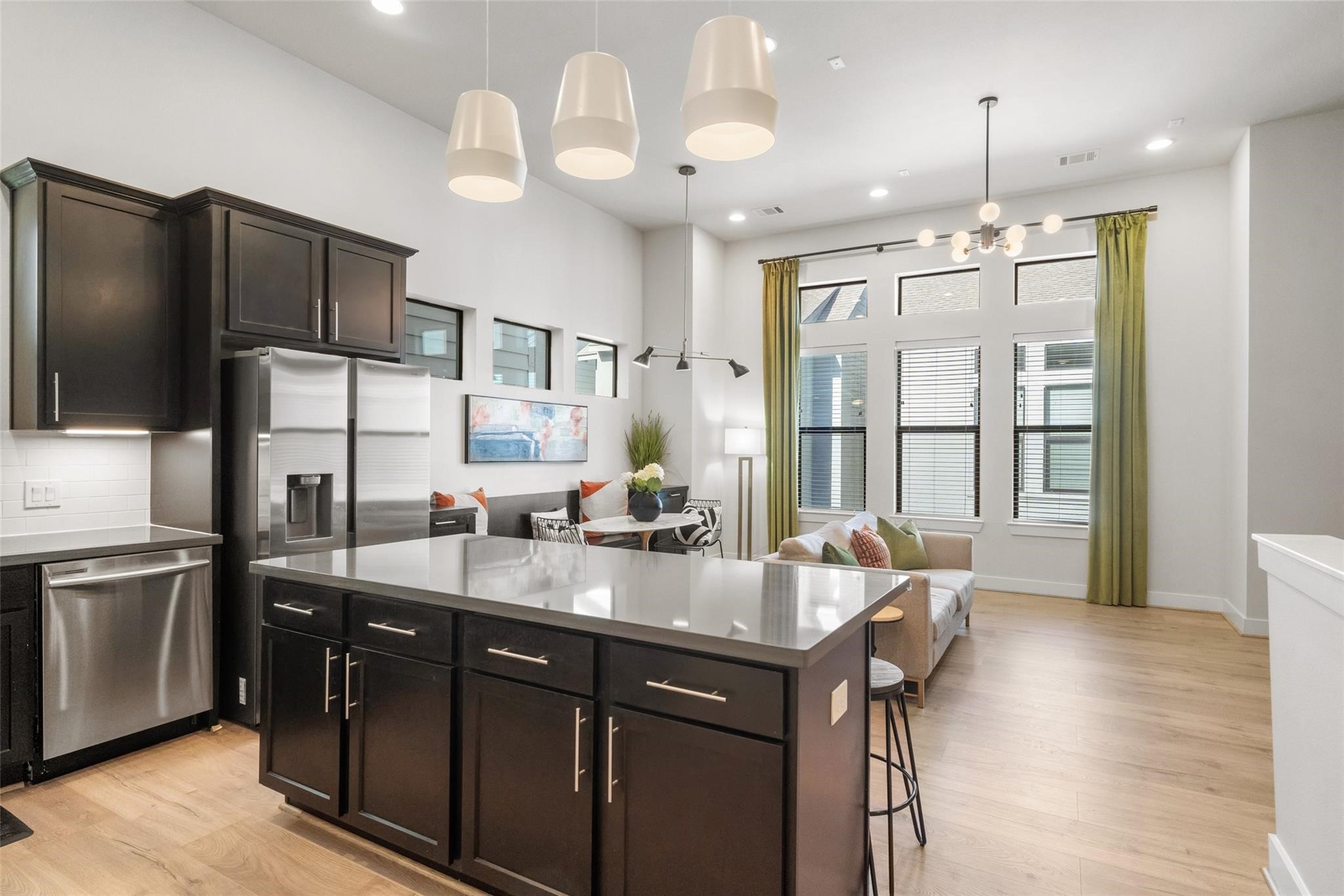 2616 Riverside Drive, Unit M Houston, TX 77004 - Photo 18 of 28 a kitchen with a refrigerator a sink dishwasher a dining table and chairs with wooden floor