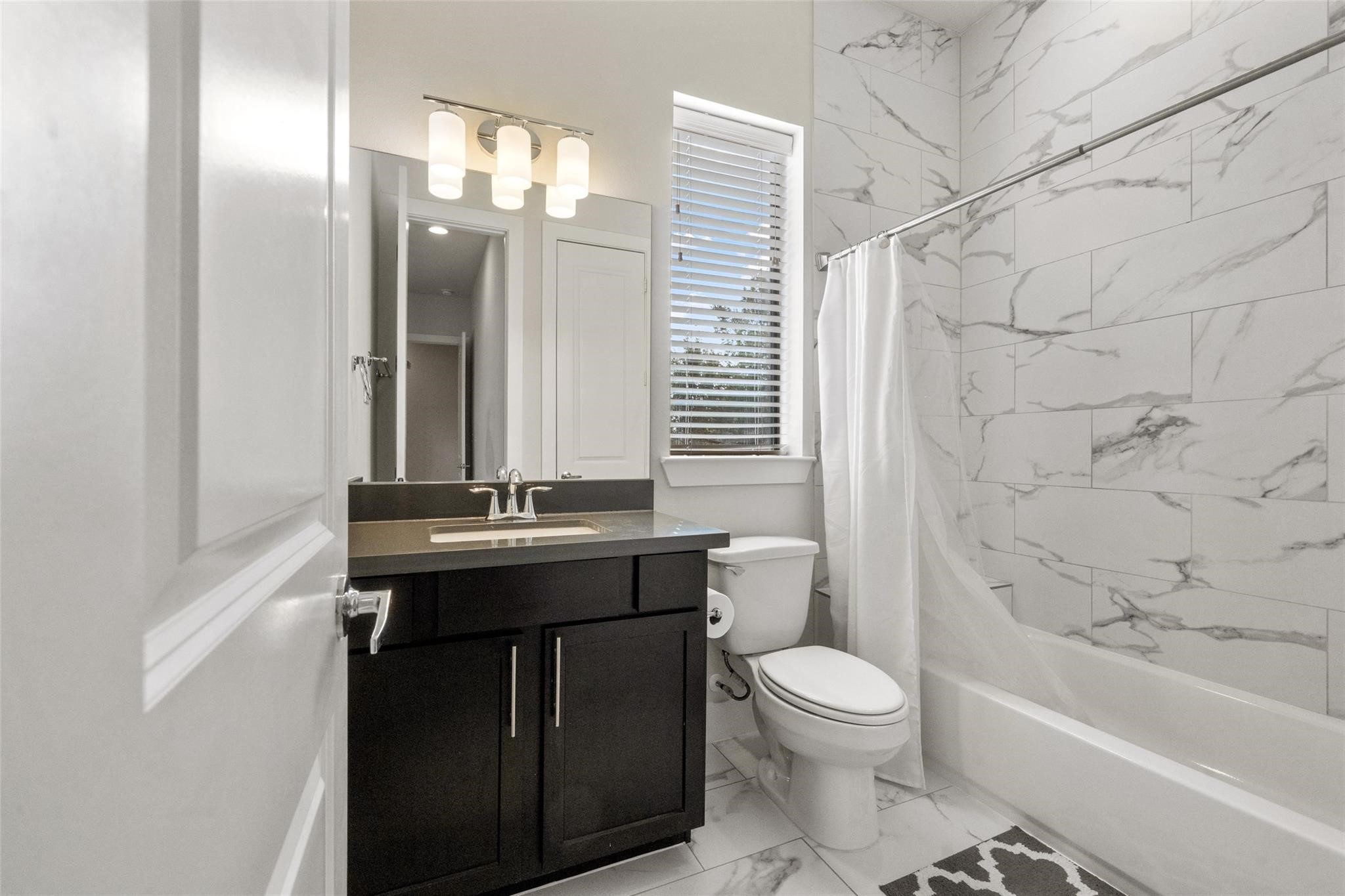 2616 Riverside Drive, Unit M Houston, TX 77004 - Photo 4 of 28 a bathroom with a granite countertop sink toilet a mirror and shower