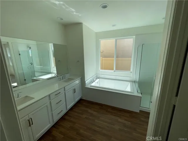 a bathroom with a granite countertop sink mirror and a bathtub
