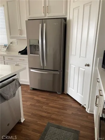 a kitchen with granite countertop a refrigerator a sink and a stove