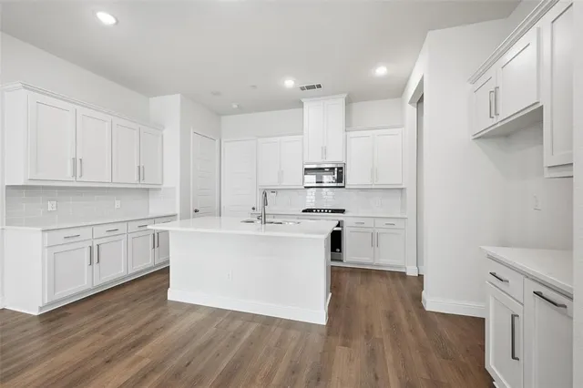 a kitchen with cabinets wooden floor and a sink