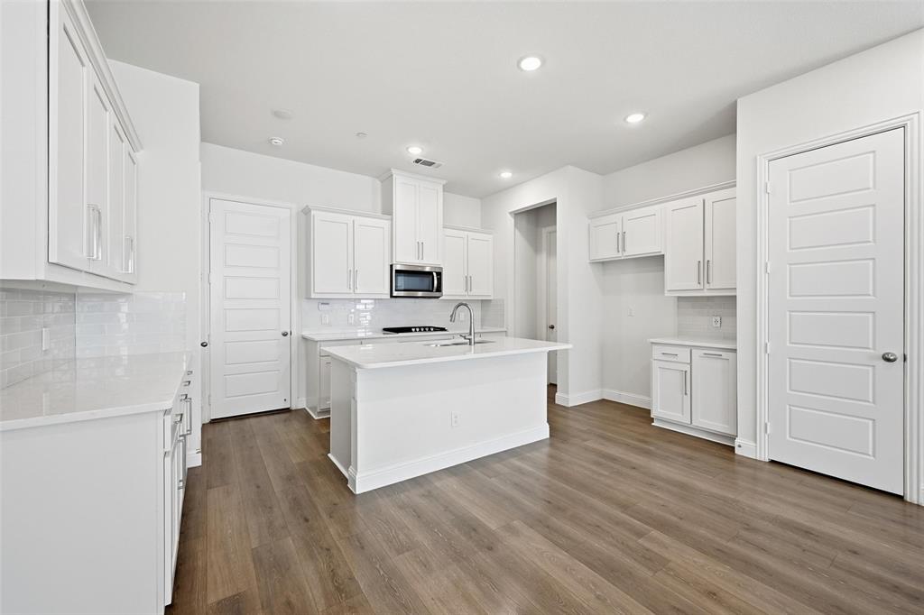 4624 Piedras Lanzar Drive McKinney, TX 75070 - Photo 6 of 20 a kitchen with white cabinets and white appliances
