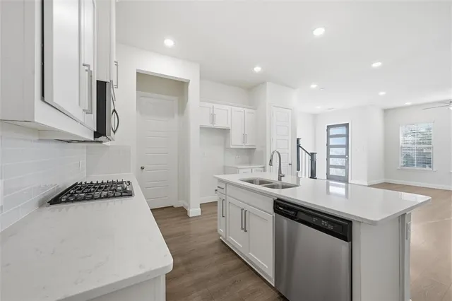 a kitchen with stainless steel appliances a sink stove and cabinets