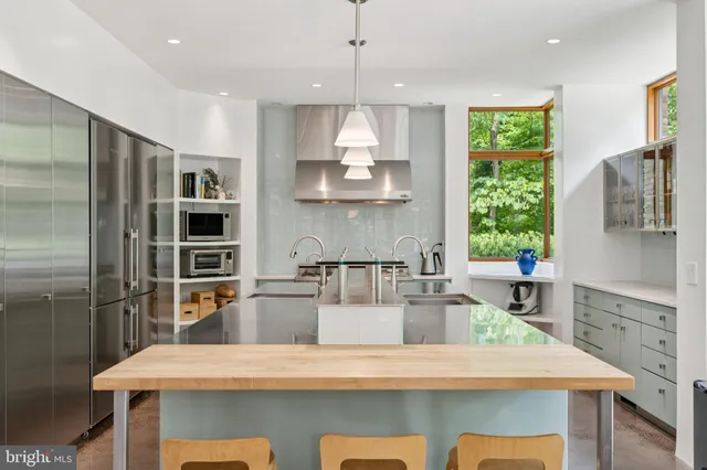 a kitchen with stainless steel appliances granite countertop a sink refrigerator and microwave