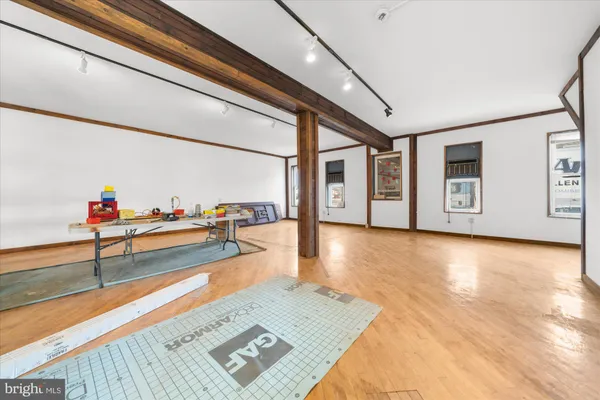 a view of an empty room with window and wooden floor