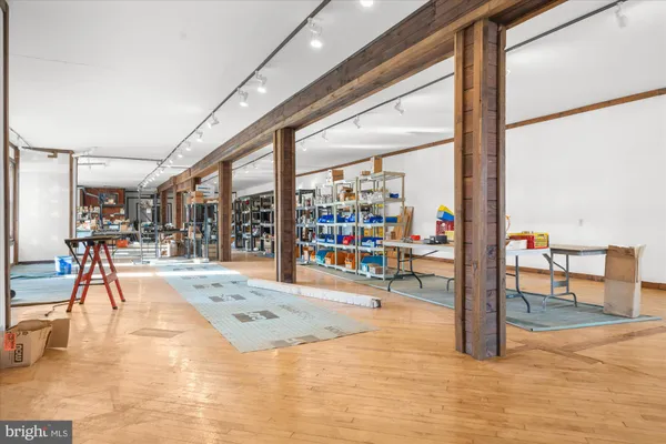 a view of an empty room with wooden floor and stairs