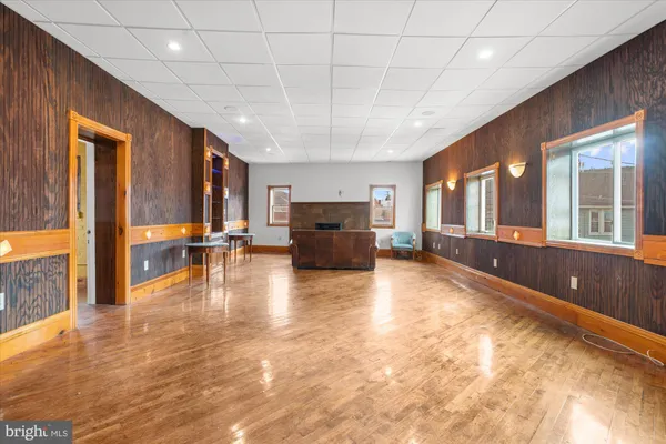 a view of a hallway with wooden floor and closet