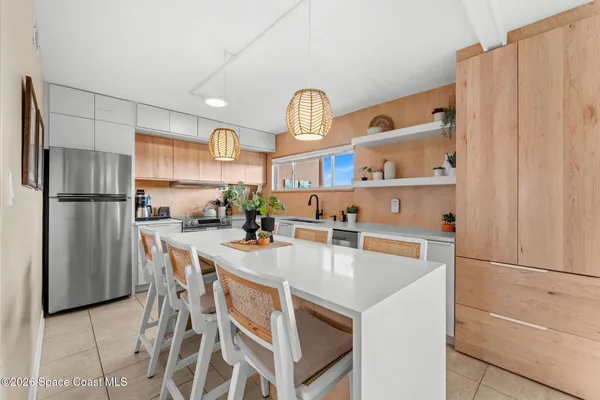 a kitchen with stainless steel appliances a stove a refrigerator and a refrigerator with white cabinets