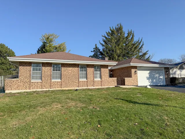 a front view of a house with a garden and yard