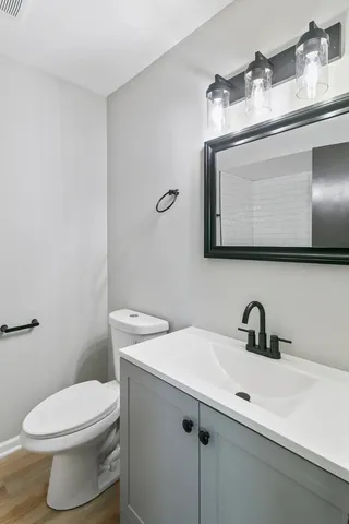 a bathroom with a toilet sink and mirror