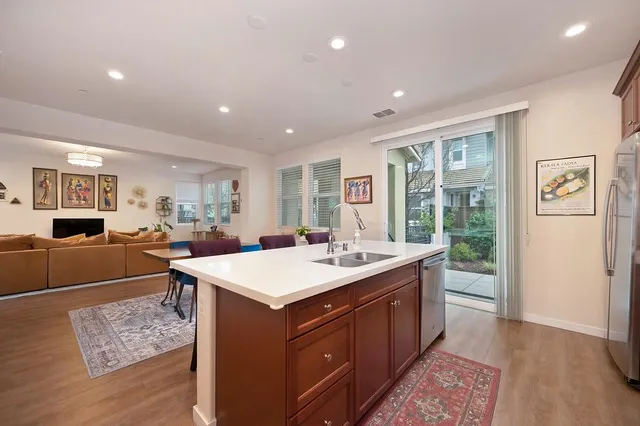 a large kitchen with kitchen island a sink a stove a refrigerator counter top space and a window