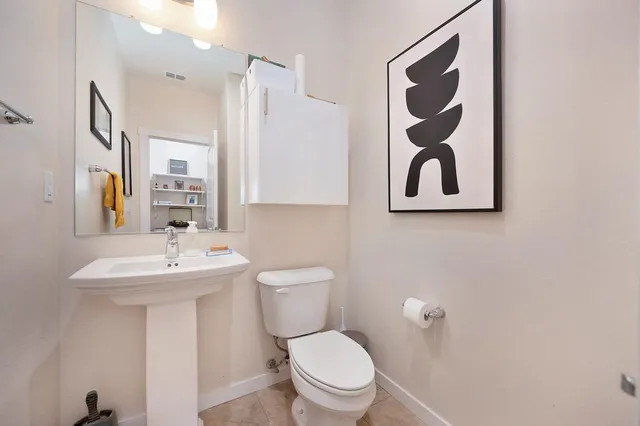 a bathroom with a toilet sink and mirror