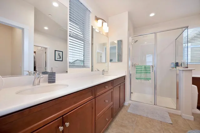 a bathroom with a double vanity sink a mirror and a shower