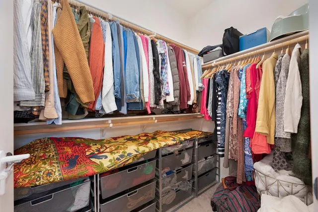 a view of a bedroom with clothes and shoes