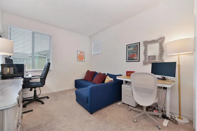 a view of a livingroom with workspace and a window