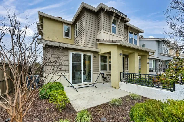 a front view of a house with a garden and plants