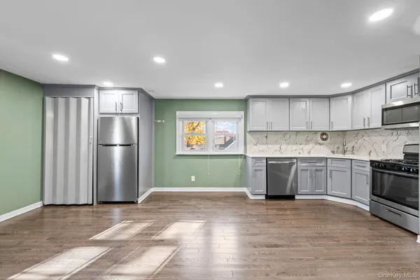 a kitchen with stainless steel appliances granite countertop a refrigerator and a stove top oven