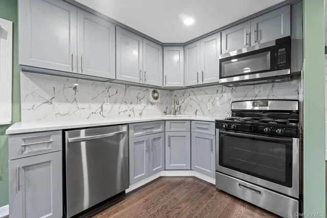 a kitchen with stainless steel appliances granite countertop a stove microwave and sink