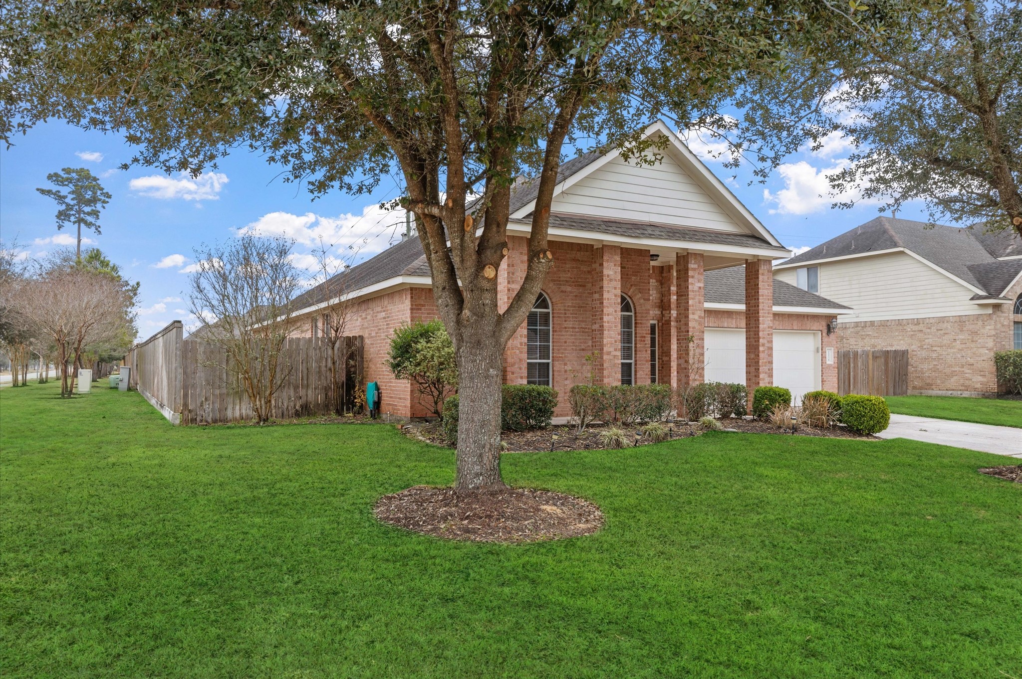 24538 Fort Settlement Drive Spring, TX 77373 - Photo 24 of 29 Charming brick home with a welcoming front porch, nestled on a spacious corner lot. Features a well-maintained lawn and mature trees, offering a serene setting. The driveway leads to a two-car garage, enhancing convenience and curb appeal.