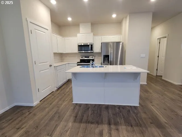 an empty room with wooden floor closet and windows