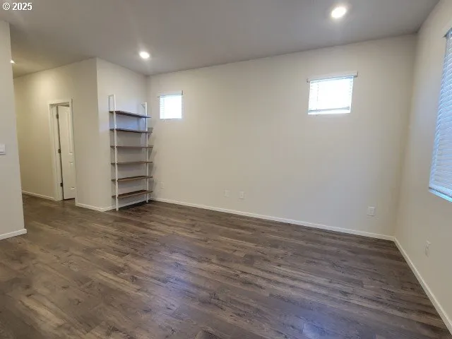 a view of kitchen with stainless steel appliances wooden floor and large window