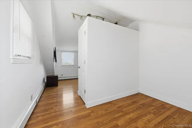 a view of a room with wooden floor and white walls