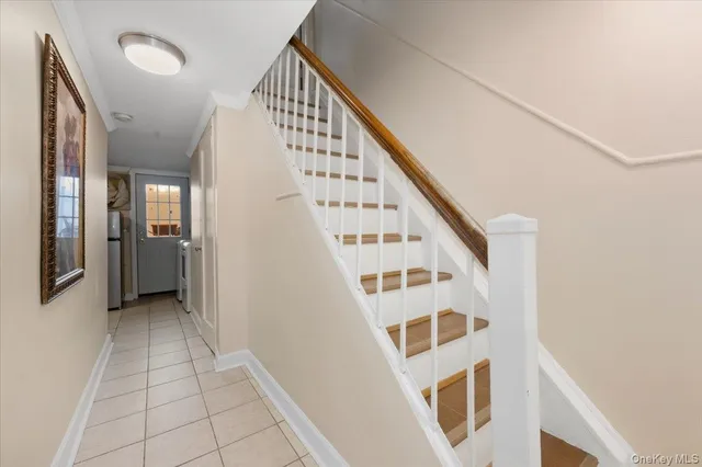 a view of staircase with railing and white walls