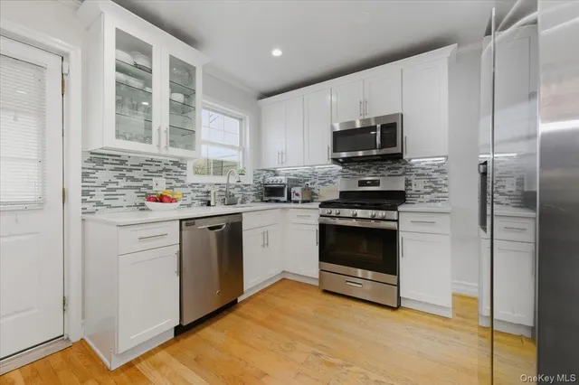 a kitchen with stainless steel appliances a stove sink microwave and cabinets