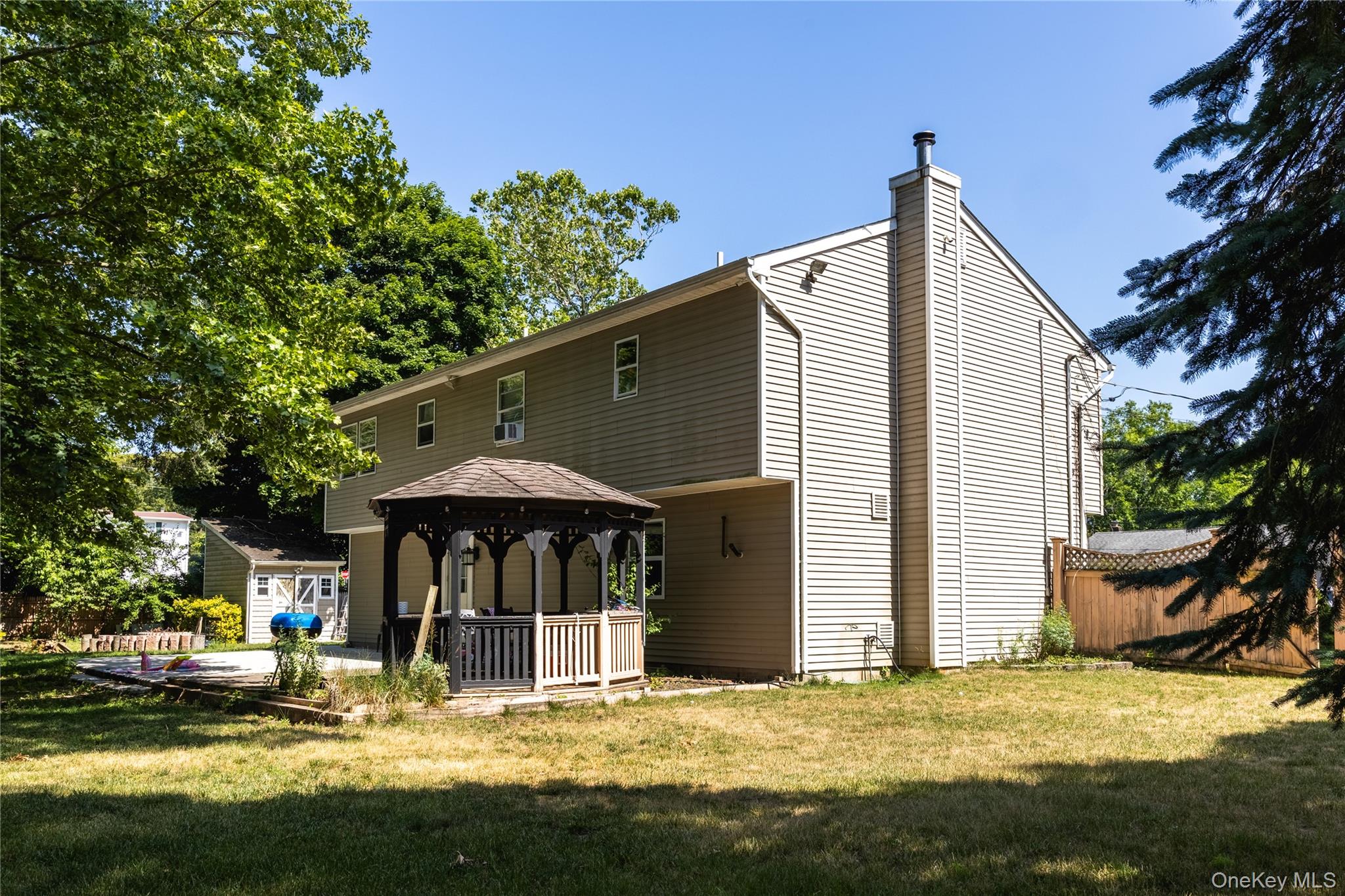 5 2 Street Coram, NY 11727 - Photo 5 of 30 Exterior featuring light-colored siding, a prominent chimney, and a multi-level structure